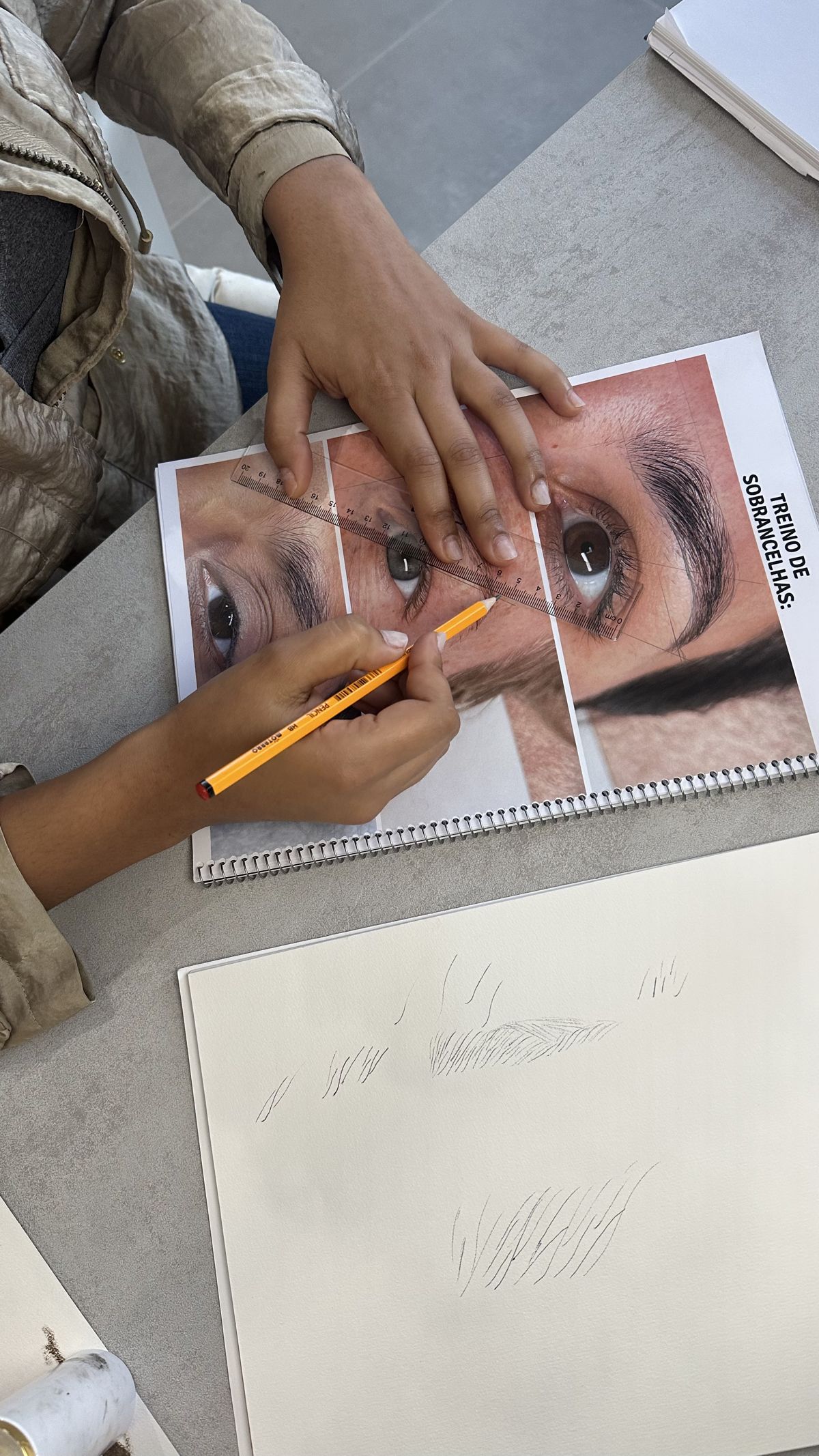 Aluna treinando o desenho de sobrancelhas no papel